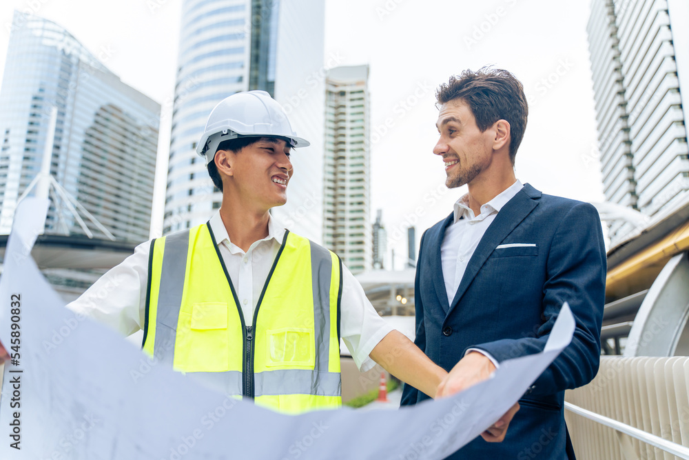 在城市户外工作的高加索商人和亚洲工人。