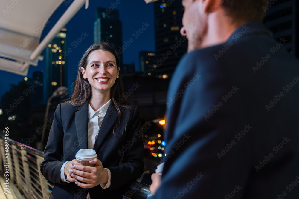 高加索年轻的商人和女人晚上站在城市的户外。