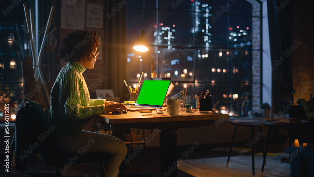 Positive Female Designer Working From Home on Laptop Computer with Green Screen Chromakey on Display