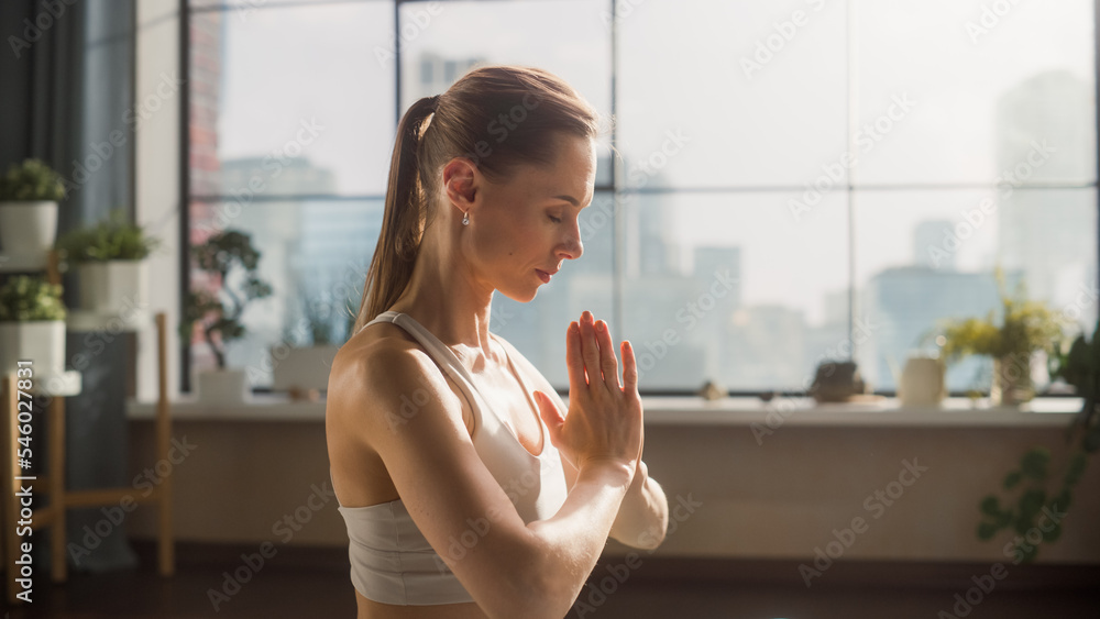 Young Beautiful Female Exercising, Practising Meditation in the Morning in Her Bright Sunny Loft Apa