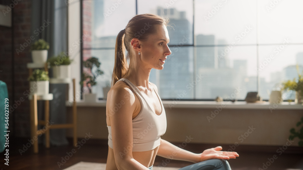 Young Beautiful Female Exercising, Practising Meditation in the Morning in Her Bright Sunny Loft Apa