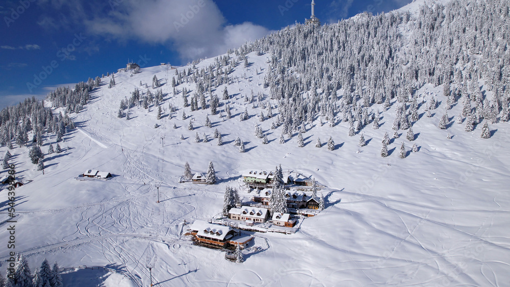 航空航天：白雪覆盖的小木屋，周围是白雪皑皑的高山滑雪场