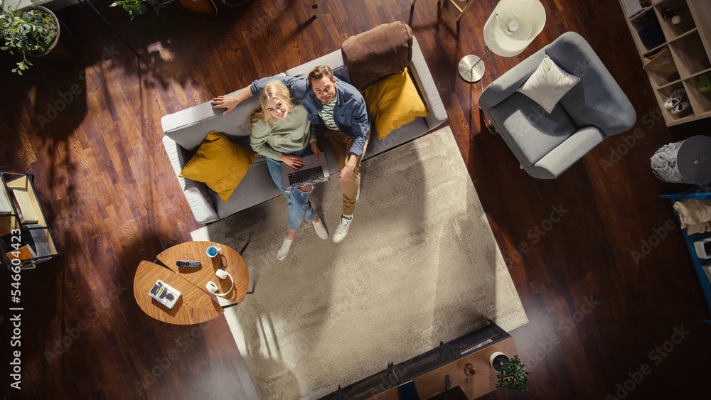 Top View Apartment: Happy Couple In Love Using Laptop in the Stylish Living Room, Hug and Look Up at