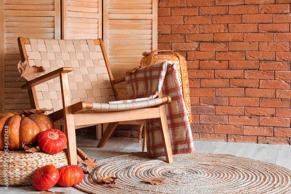 Rattan armchair and pumpkins in interior of modern room