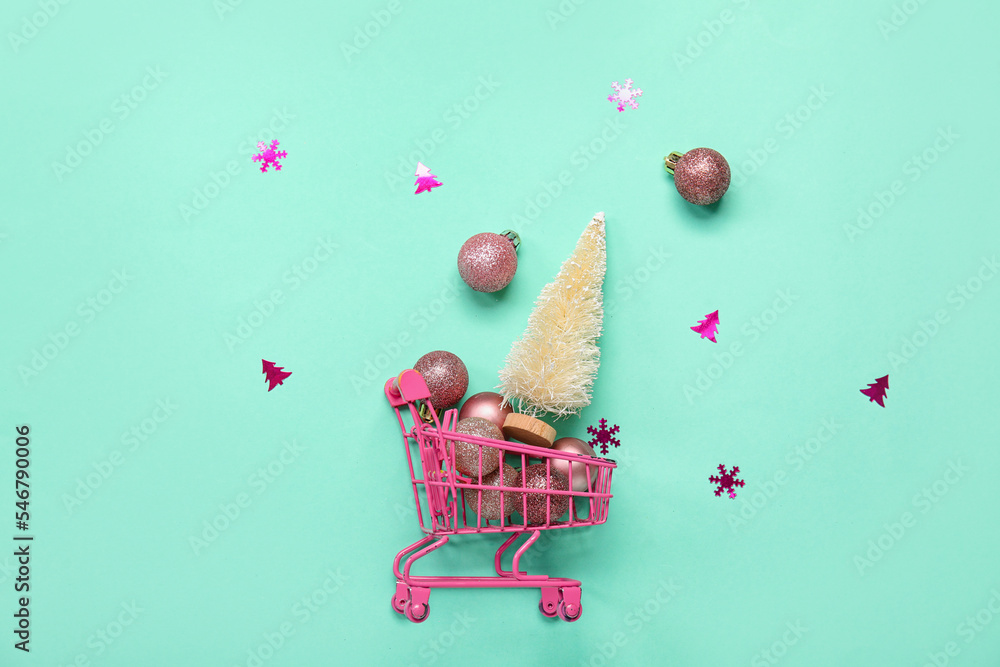 Shopping cart with Christmas tree and balls on blue background