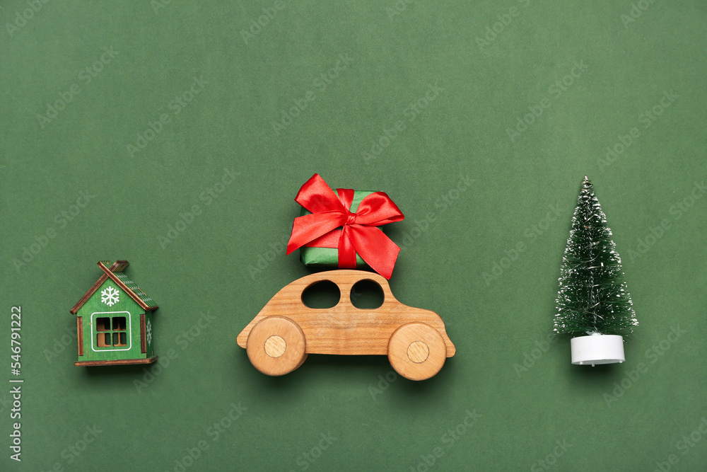 Toy car with gift, Christmas tree and house figure on green background