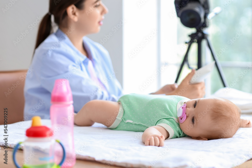 带着奶油和小婴儿在家录制视频课程的年轻女性