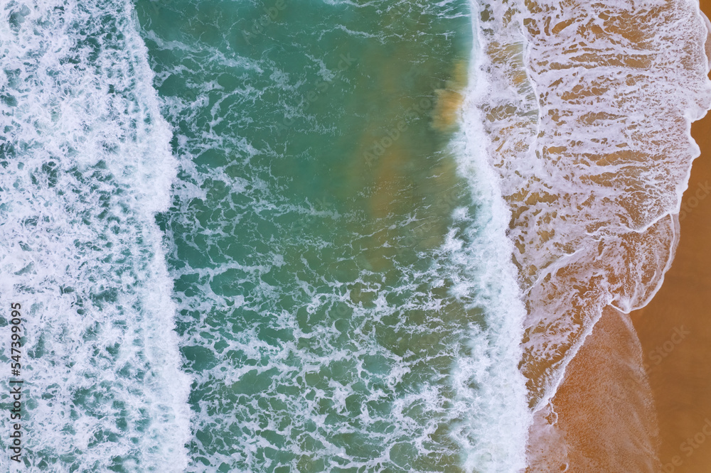 海浪冲击的鸟瞰图海滩沙滩上的白色泡沫波浪，海滩海景俯视图Na