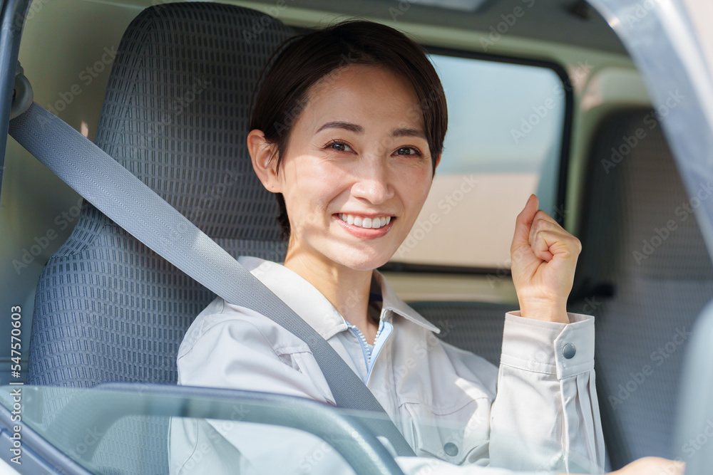 運転席でガッツポーズをする女性