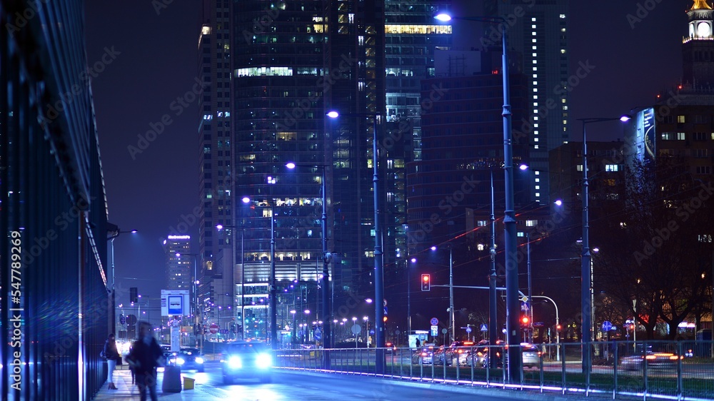 市中心的晚间城市生活。街上的汽车。夜晚的城市路灯。