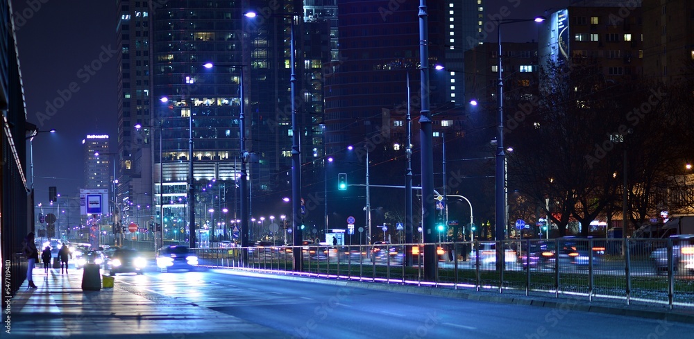 市中心的晚间城市生活。街上的汽车。夜晚的城市路灯。