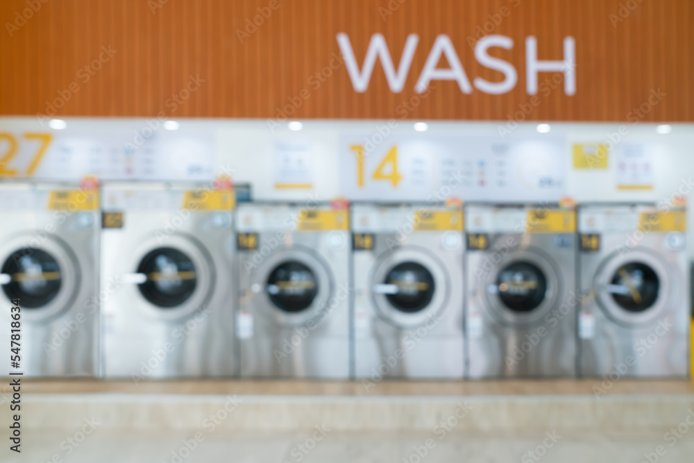 Blur background of of qualified coin-operated washing machines in a public store. Concept of a self 