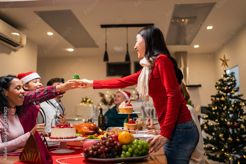 Multi-ethnic big family celebrating Christmas party together in house. 