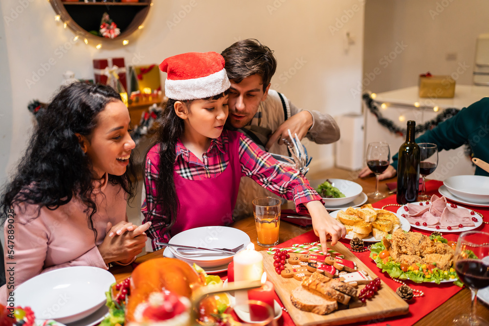 Multi-ethnic big family celebrating Christmas party together in house. 