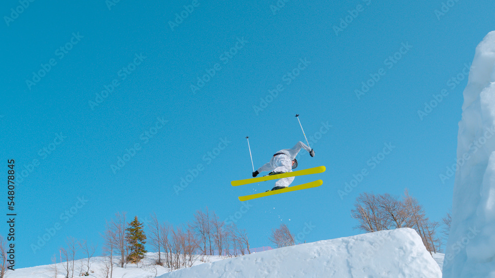 低角度视角：年轻的自由式滑雪运动员在滑雪场的雪上公园跳得很大