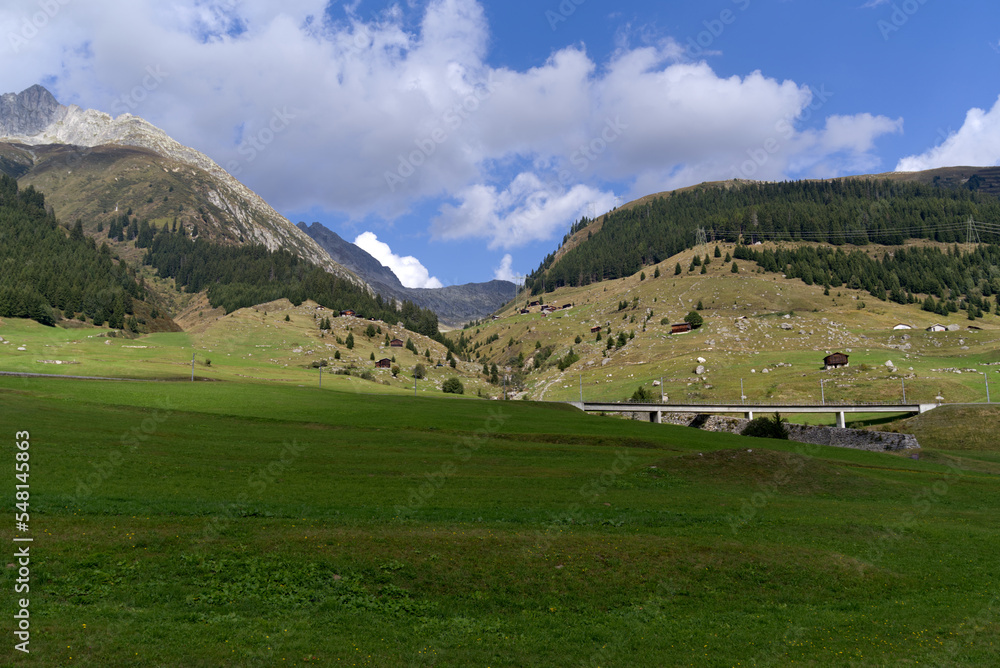 Concrete railway viaduct at mountain village Rueras, Canton Graubünden, on a blue cloudy late summer