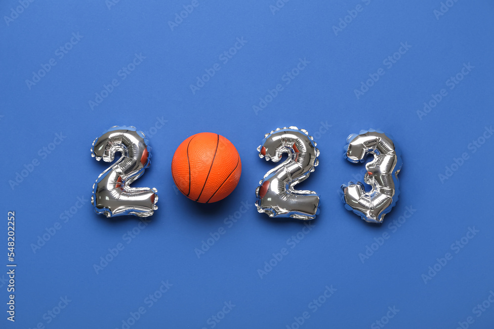 Figure 2023 made of balloons and ball on blue background