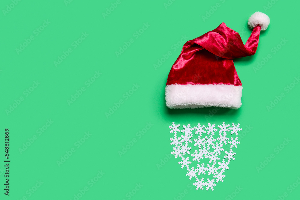 Santa hat and beard made of snowflakes on green background