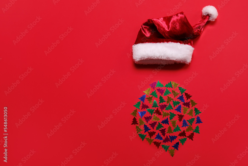 Santa hat and beard made of confetti on red background