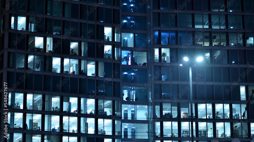 Modern office building in city at the night. View on illuminated offices of a corporate building. Bl