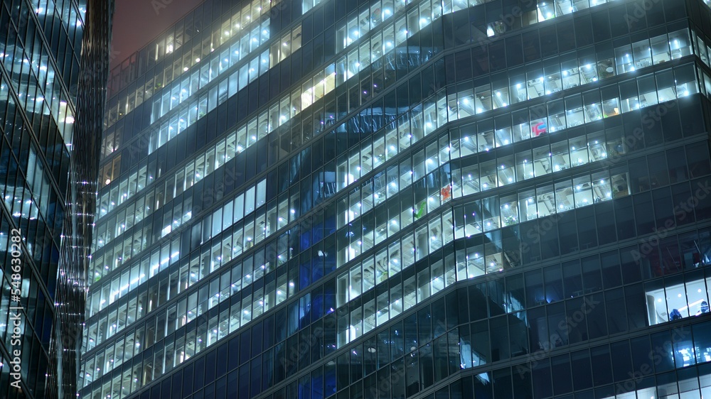 Modern office building in city at the night. View on illuminated offices of a corporate building. Bl