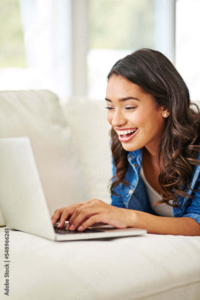 Woman, laptop and smile for good news on sofa reading email, blog or relaxing in social media at hom