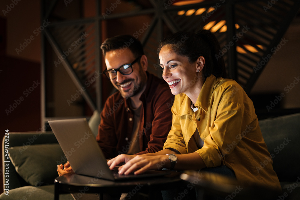 Businesswoman working over the laptop while her male colleague sitting next to her.