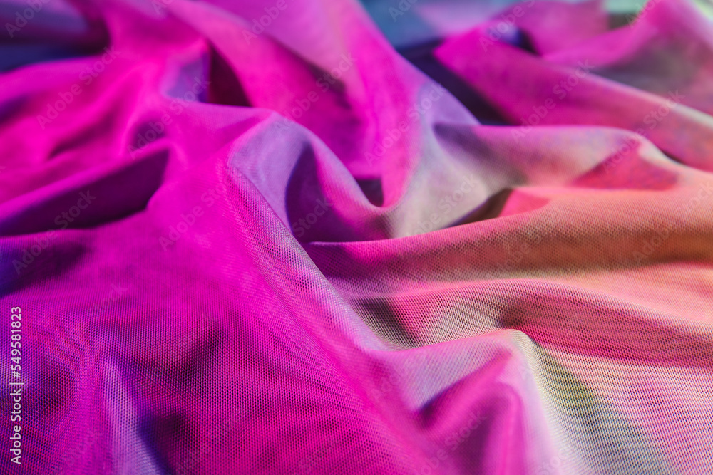 Crumpled fabric in neon light as background