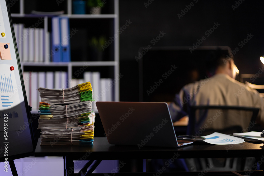 Responsible and determined businessman working overtime on computer in the night office.