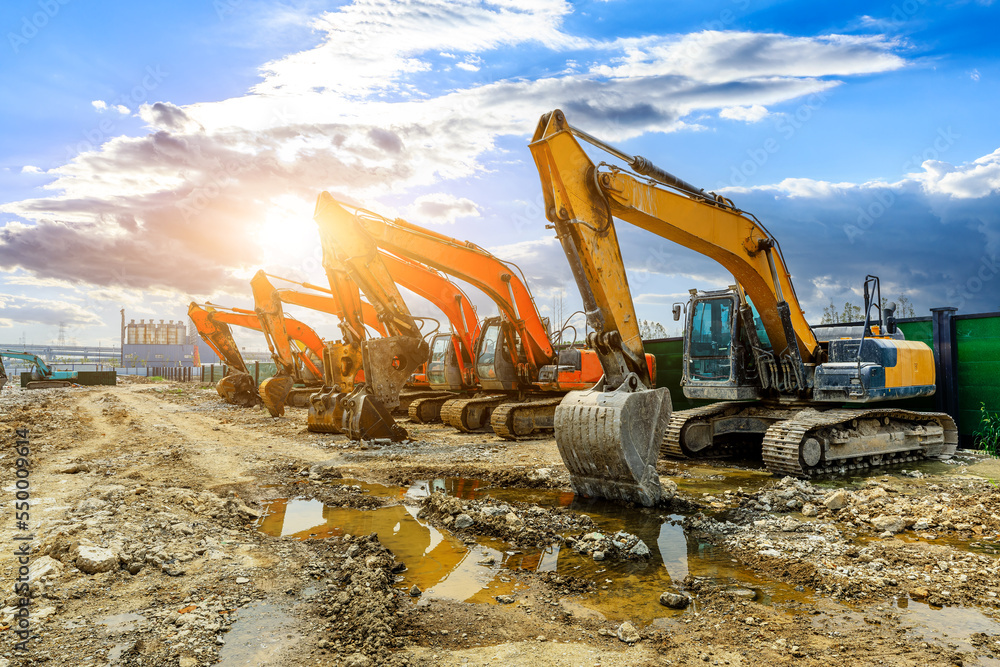 Construction site excavator equipment scene at sunset