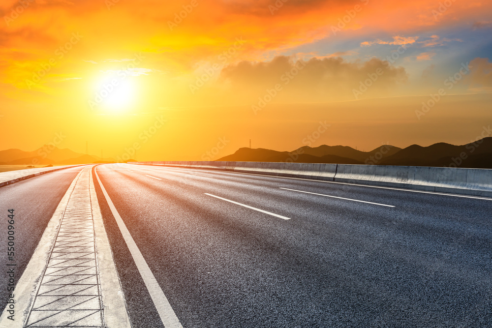 Asphalt road and mountain natural landscape at sunset