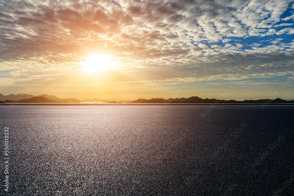 Asphalt road and sea with mountain nature background at sunrise