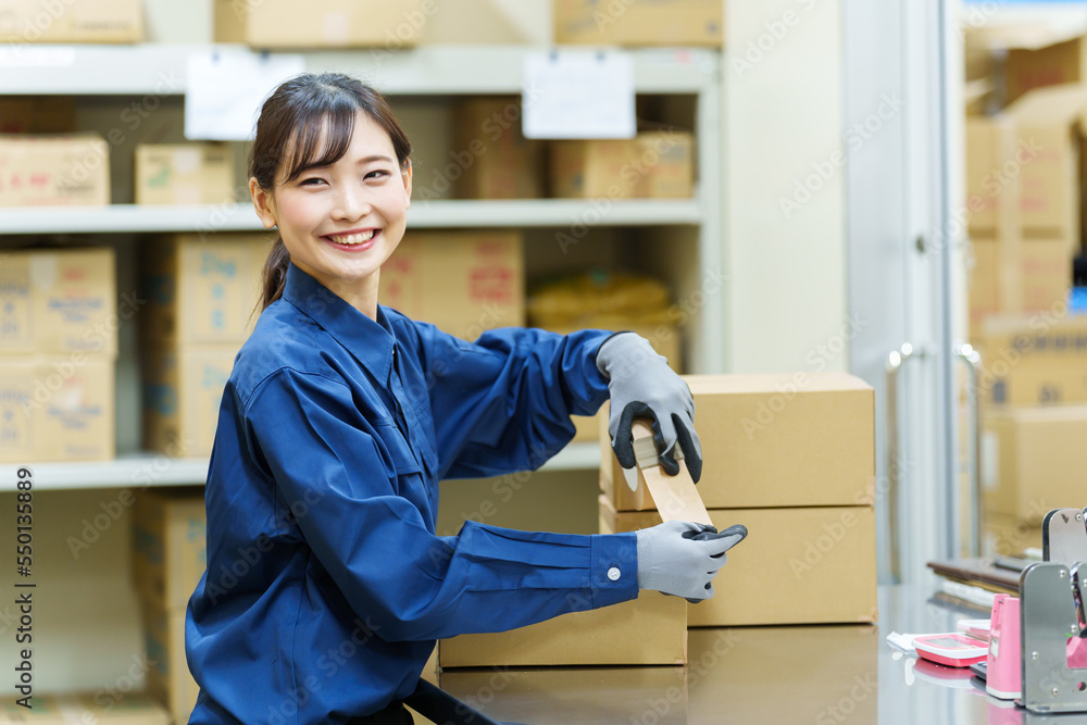 倉庫で梱包をする女性作業員