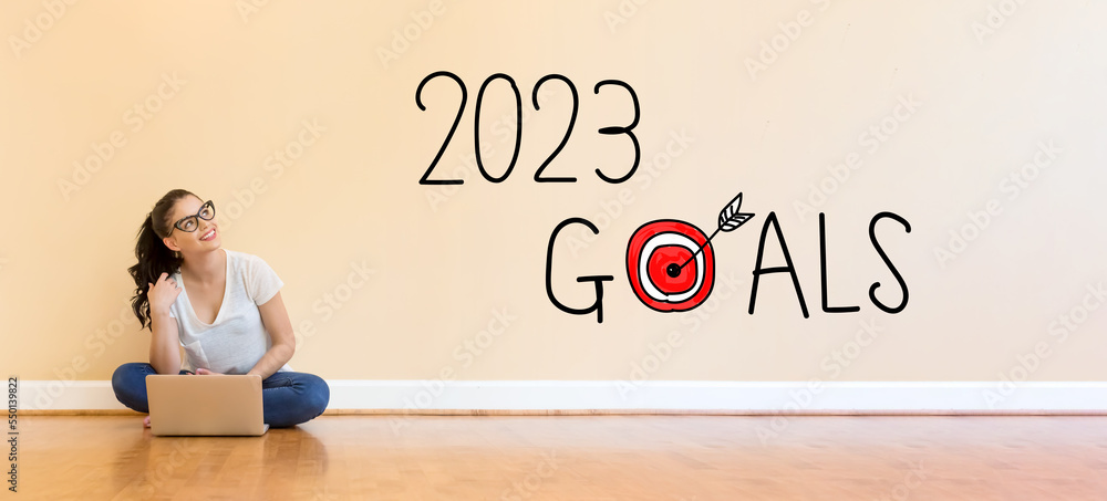 2023 Goals text with young woman using a laptop computer on floor