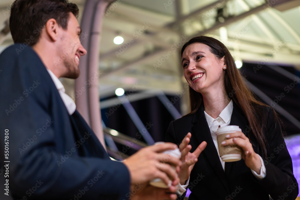 Caucasian young businessman and woman stand outdoor in city at night. 