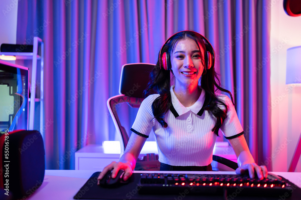 Portrait of Asian esport woman gamer play online video game on computer. 