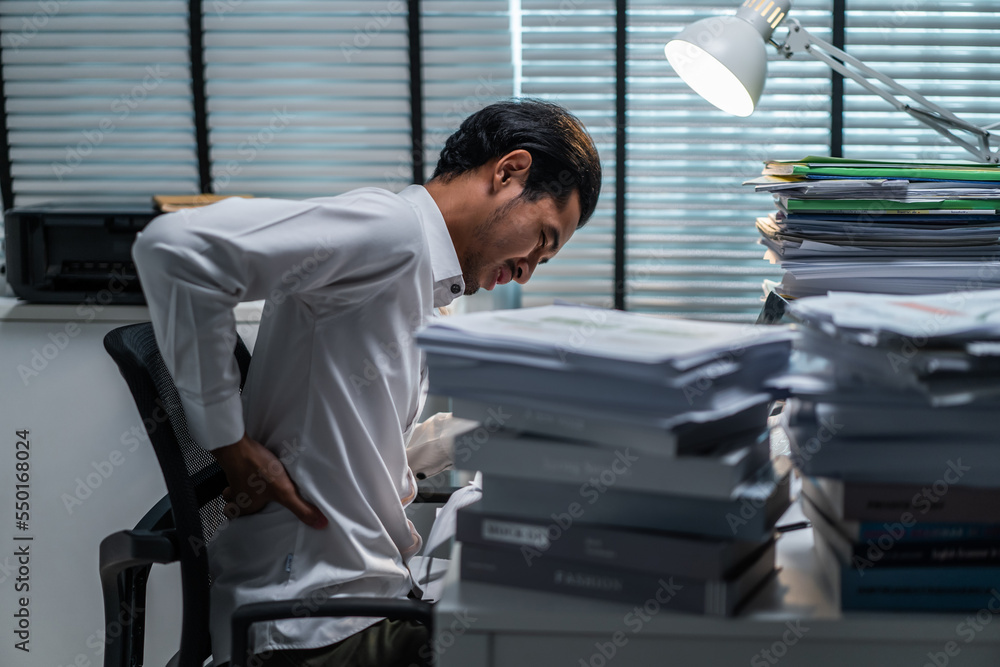 Exhausted Asian young businessman worker working on table in office. 