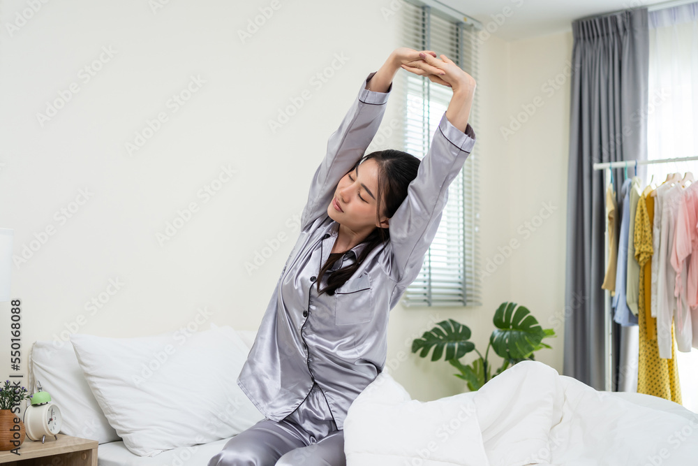 Asian beautiful girl in pajamas wake up in the morning with happiness. 