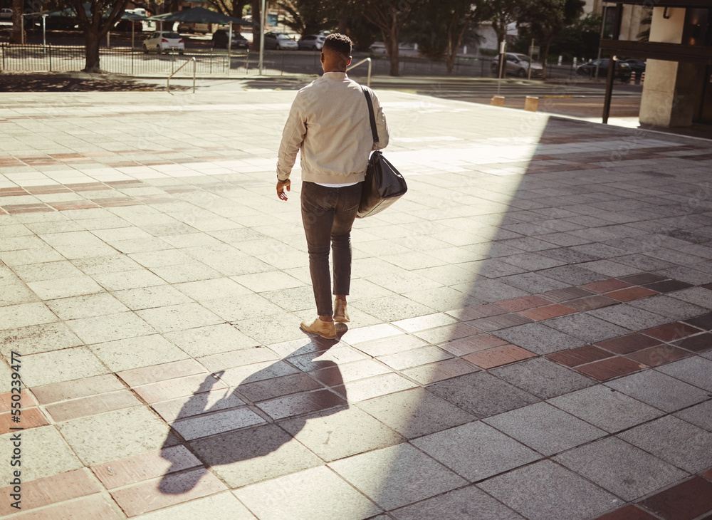 Business, travel and city with a young man walking outdoors against an urban background in the day. 