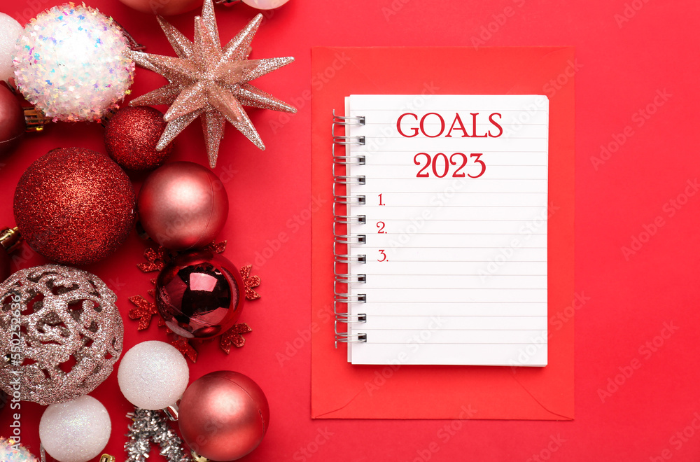 Composition with to-do list for year 2023 and Christmas decorations on red background