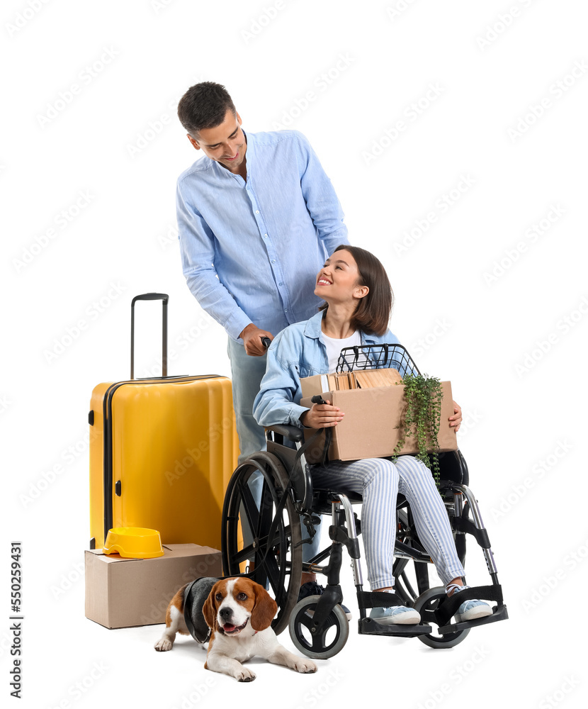 Young man with his wife in wheelchair, moving boxes, suitcase and dog on white background