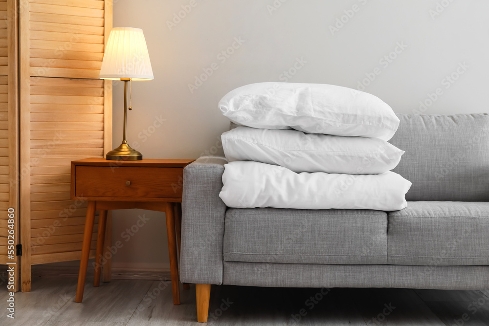 Stack of blanket and pillows on comfortable sofa