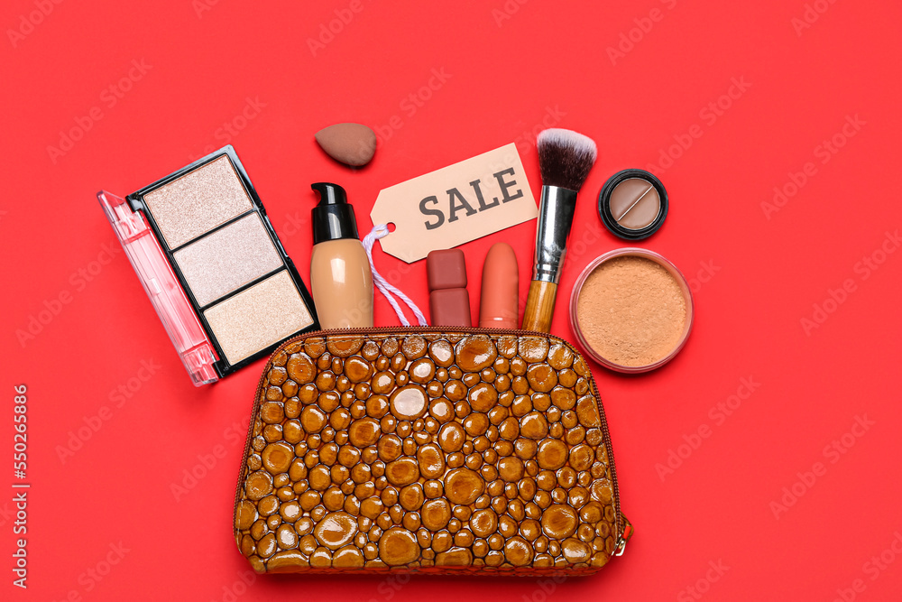 Bag with cosmetic products, accessories and sale tag on red background