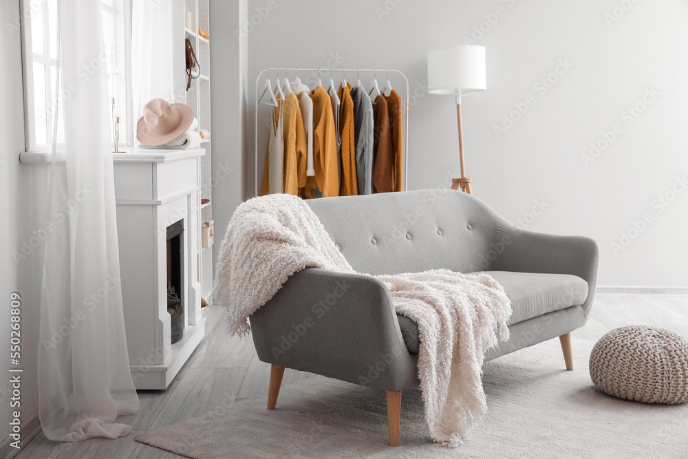 Interior of modern living room with sweaters, fireplace and sofa