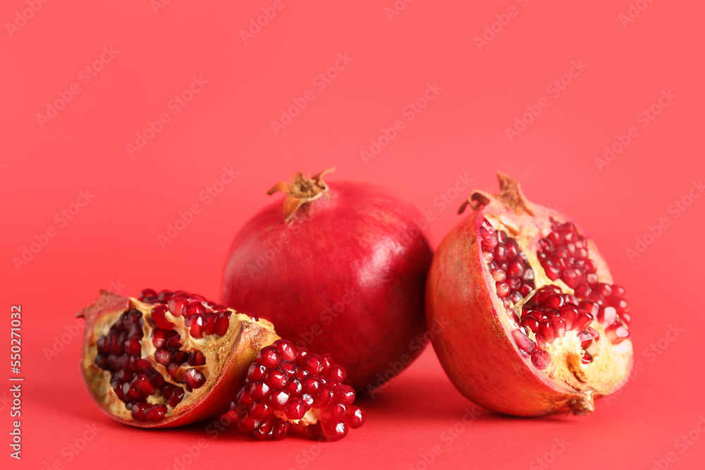 Fresh pomegranates on red background