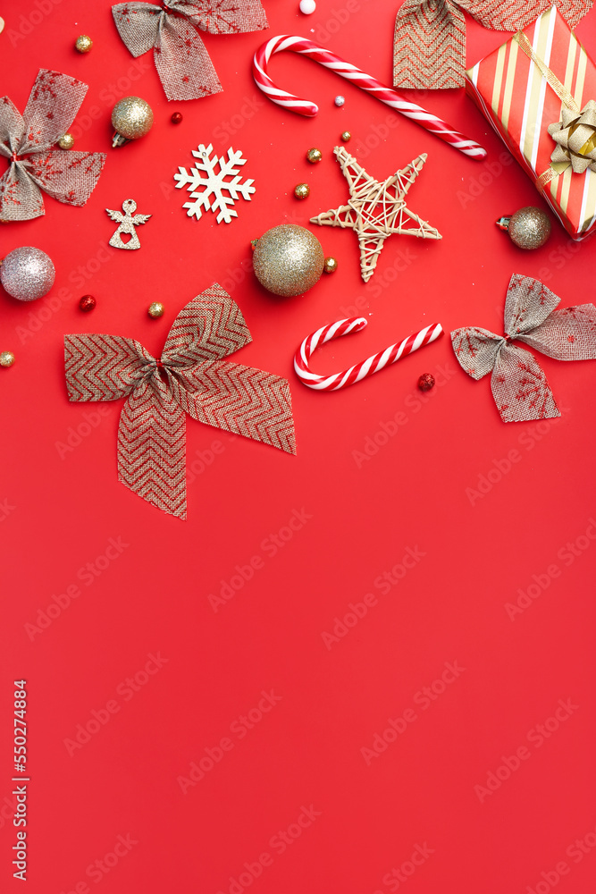 Composition with beautiful Christmas decorations and candy canes on red background