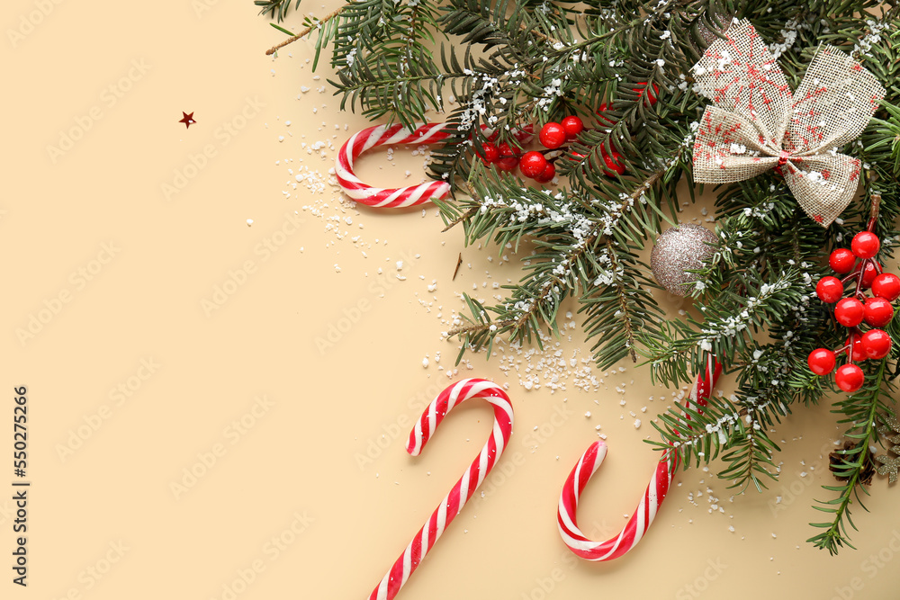 Composition with fir branches, candy canes, Christmas decorations and snow on color background