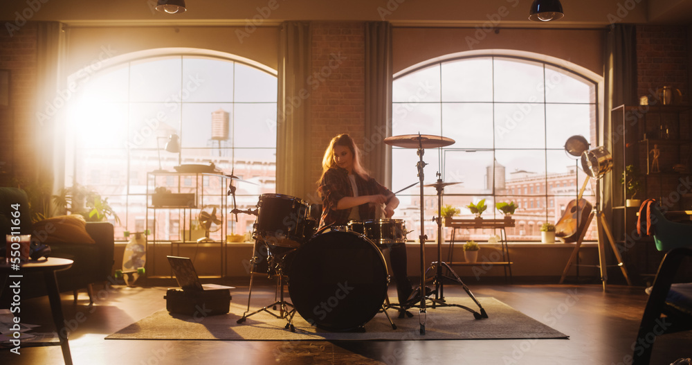 Young Female Playing Drums During a Band Rehearsal in a Loft Studio with Warm Sunlight at Daytime. D