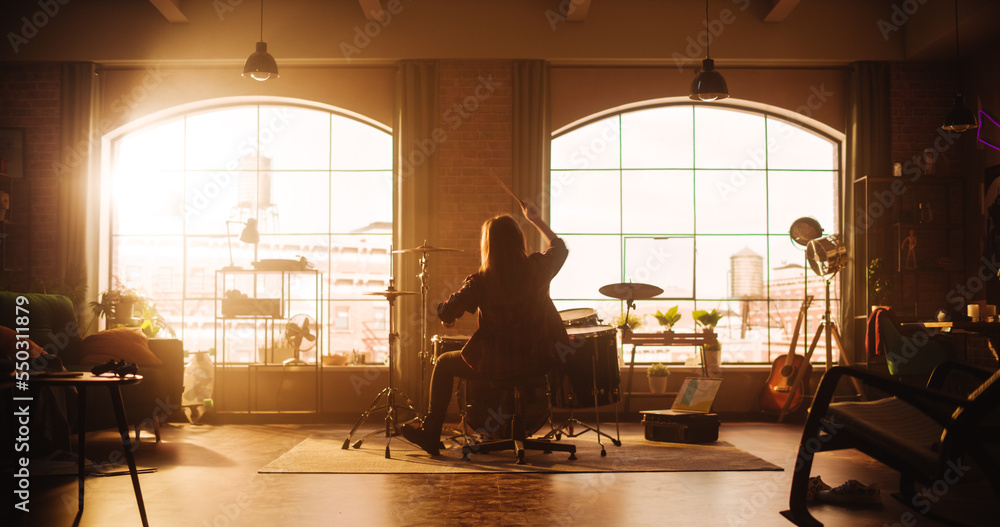 Person Sitting with Their Back to Camera, Playing Drums During a Band Rehearsal in a Loft Studio wit