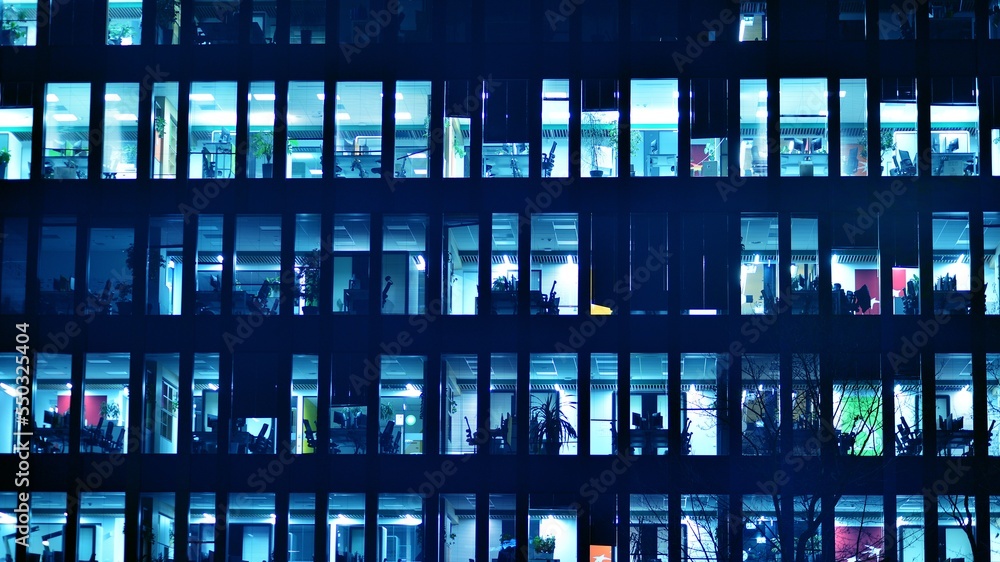 Pattern of office buildings windows illuminated at night. Glass architecture ,corporate building at 